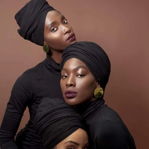 Solid black stretch headwrap for women shown on multiple models with a brown background