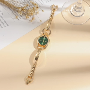 Detail of vintage gold bracelet watch with emerald green dial and Roman numerals