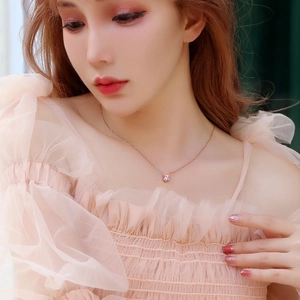Detailed close-up of a rose gold necklace with a round-cut zircon on a model's neck