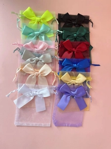 Flat lay of colorful organza gift bags with satin ribbons and drawstring closures