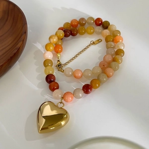 Multicolor natural stone beaded necklace with a gold heart pendant on white background