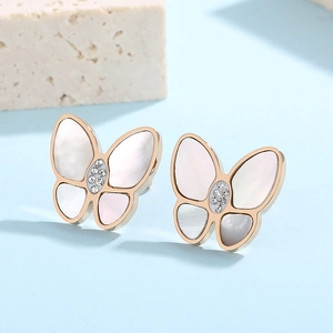 Detailed macro view of 3D butterfly earrings with white shell and inlaid crystals