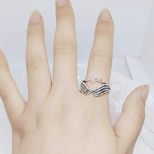 Gothic silver skeletal hand heart ring for women and men in a vintage punk style