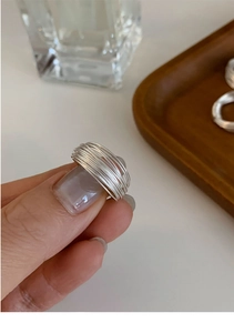 Macro shot of minimalist multi-layered silver geometric ring with elegant wire winding