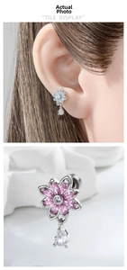 Macro detail of silver flower stud earrings with zircon petal and pear-cut waterdrop pendant