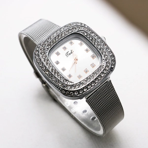 Detail of silver square quartz watch with rhinestone bezel and Milanese mesh band