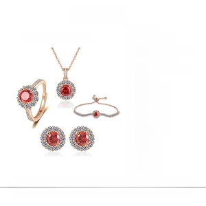 Detail view of champagne gold jewelry set featuring red stones and petal halo design