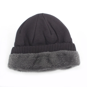 Detail view of the thick gray plush faux fur lining inside a knitted winter beanie hat