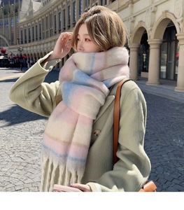 Close-up of thick pastel plaid scarf with soft fringe on a model in sunny outdoor street