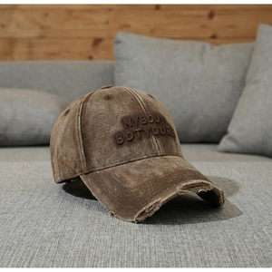 Close-up of distressed cotton baseball cap with 3D embroidery and frayed brim details