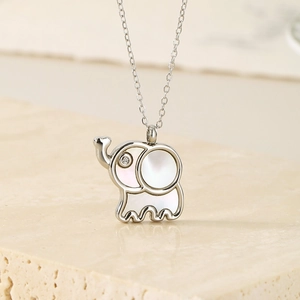 Macro shot of silver elephant pendant with mother-of-pearl inlay and zircon eye