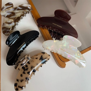 Collection of five elegant curved hair claws in marble, red, black, white, and leopard