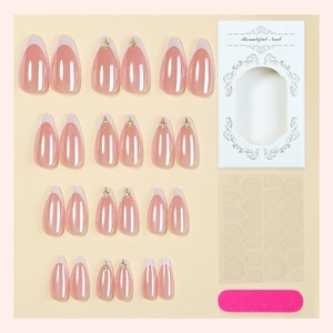 Pink French almond press-on nails set with gold star accents and manicure tool kit