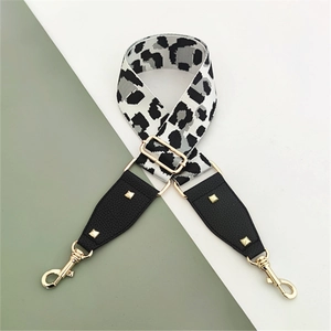 Detail of adjustable leopard print bag strap with gold rivets and metallic hook hardware