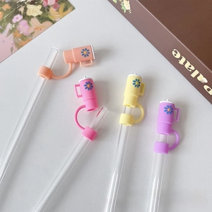 Close-up of mini coffee cup silicone straw covers in pastel colors with glass straws