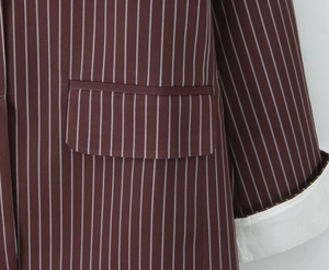 Detailed view of striped blazer fabric with pocket and contrasting white folded cuffs