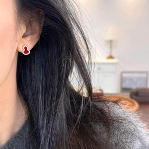 Elegant gold-plated red wulu stud earrings with zirconia stones worn on earlobe