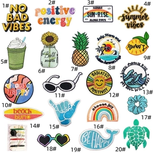 Detailed flat lay of 20 summer beach theme iron-on embroidery patches with a mini sewing kit