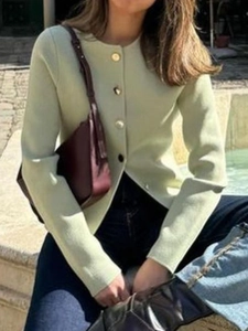 Women's light green knit cardigan with gold buttons worn by a model in an outdoor street setting