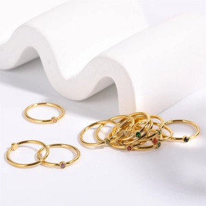 Minimalist stackable gold birthstone rings set featuring colorful round gemstones