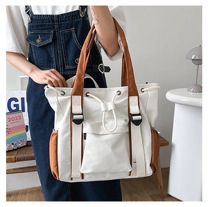 Detail of multi-pocket canvas tote bag showing drawstring pocket and contrast colors