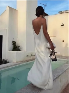 Elegante abito midi in raso bianco con schiena scoperta in una lussuosa piscina