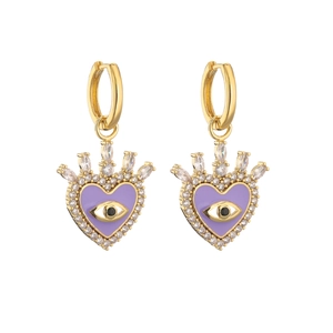 Close-up of golden heart earrings with purple enamel evil eye and sparkling zircon crown