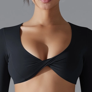 Dettaglio di un top da yoga nero a maniche lunghe con elegante scollo a incrocio e vestibilità slim