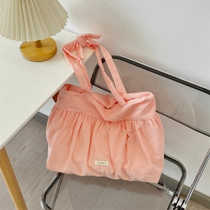 Detail of ruffled pink canvas tote bag showing soft fabric texture and knotted bow strap