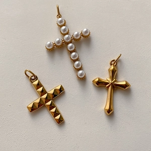 Tre ciondoli a croce placcati in oro con decorazioni di perle e motivi geometrici