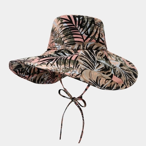 Détail d'un chapeau de soleil à large bord avec imprimé tropical et ruban de serrage