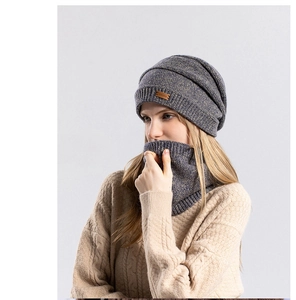 Détail d'un ensemble bonnet et écharpe en tricot bleu foncé avec écusson en cuir