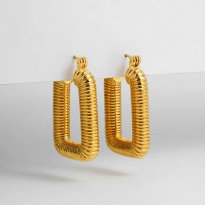 Macro detail of gold rectangular hoop earrings with fine threaded texture finish