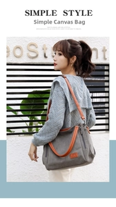 Detail of grey canvas tote with brown leather straps and side zipper pocket