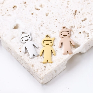 Polished boy shape metal pendants in silver, gold, and rose gold on a textured stone