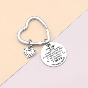 Detail view of a silver heart-shaped keychain with engraved soulmate message and crystal