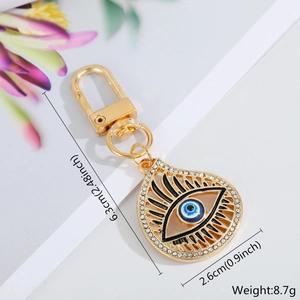 Detail view of gold Evil Eye charm with blue enamel and dimensions: 6.3cm long, 8.7g weight
