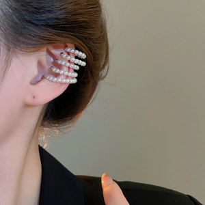 Close-up of elegant four-layer pearl ear cuff on model ear with silver-tone metal frame