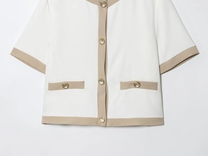 Detail of short sleeve white blazer with khaki trim and embossed gold buttons