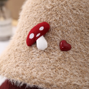 Detailed close-up of a plush beige bucket hat with cute mushroom and heart embroidery