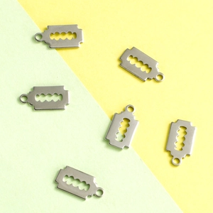 Punk style stainless steel razor blade pendants on a two-tone minimalist background