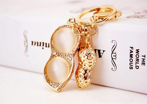 Close-up of golden peanut keychain with opal stones and sparkling rhinestones