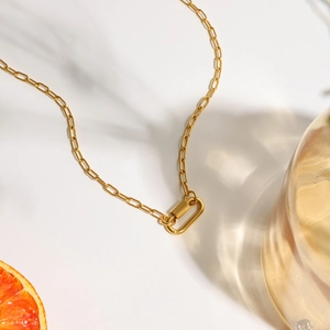 Detalle de collar de cadena de clip en oro de 18K con cierre de mosquetón geométrico