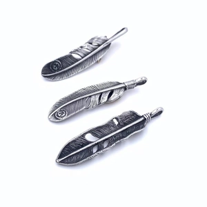 Detailed view of silver titanium steel eagle feather pendants with vintage carvings
