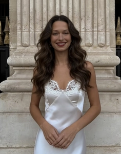 Detalle de vestido lencero de satén blanco con escote de encaje y acabado sedoso