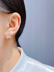 Macro shot of gold-plated geometric square zircon ear cuff on ear without piercing