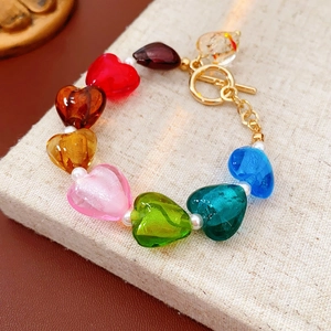 Detailed shot of heart-shaped glass beads and pearls bracelet with gold T-bar clasp