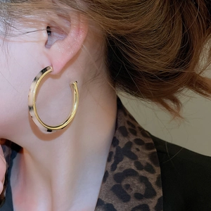 Close-up of vintage large C-shaped tortoiseshell resin hoop earrings on model