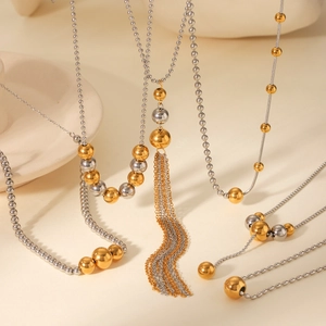 Detailed close-up of 18K gold and silver two-tone beaded necklace with elegant metal tassels