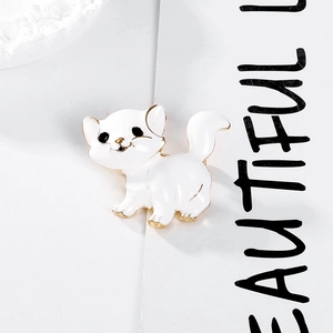Detail of cute white enamel cat brooch with gold edges on a decorative lace plate